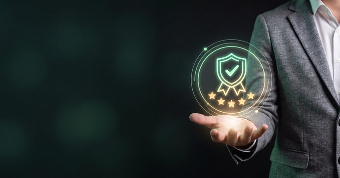 Businessman holding glowing quality assurance shield icon representing digital service excellence standards with holographic five star customer feedback interface display