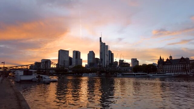 Beautiful panoramic sunset skyline view of frankfurt city center with modern skyscrapers and river reflection.