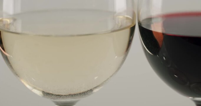 Elegant red wine swirling inside a traditional crystal glass in super slow motion, creating beautiful waves and releasing its bouquet against a smooth, refined gray gradient background