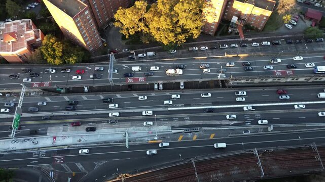 Sydney NSW Australia.Traffic on the M1 North Sydney highway.Bradfield highway.Traffic flows on a busy highway with trains above in a city near sunset