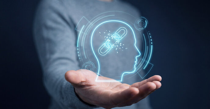 Digital human head profile with breaking chain hologram hovering above hand representing mental health liberation freedom and cognitive breakthrough concept