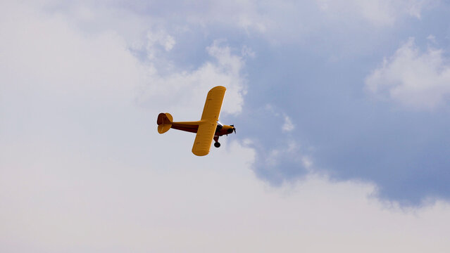 Vintage Yellow Light Aircraft Flying Through Cloudy Skies Over Geelong