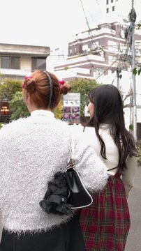 Young Women Walking Through Harajuku Street in Tokyo Japan