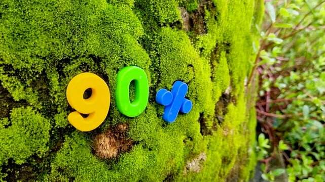 Zero percent sign on mossy tree bark with falling yellow cube number moss nature green texture