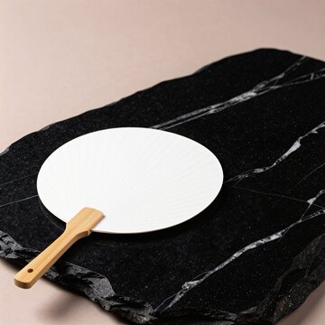 Plain white uchiwa fan on black stone