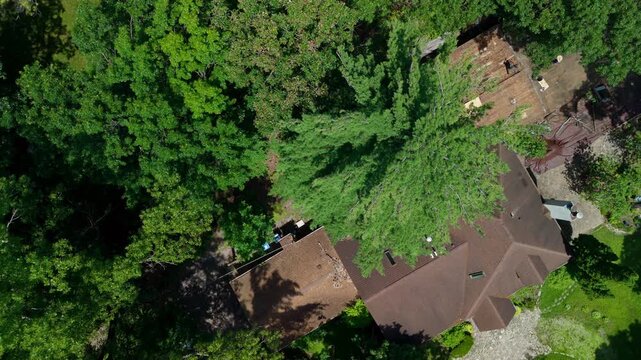 Aerial drone view of a residential home during a roof replacement project. Exposed roof decking, partially installed plywood sheathing, and roofing contractors