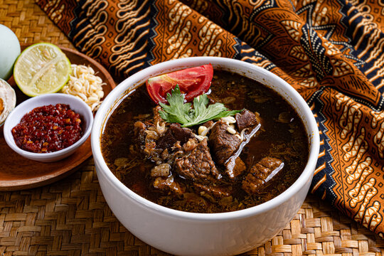 Authentic javanese rawon dark soup plated with cultural batik fabric
