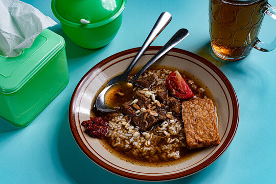 Authentic indonesian nasi rawon beef black soup with tempeh in local warung setting
