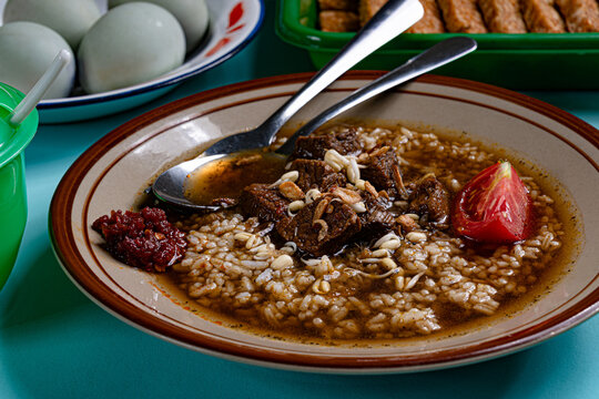 Close up of east javanese nasi rawon mixed rice with beef and sambal on blue table