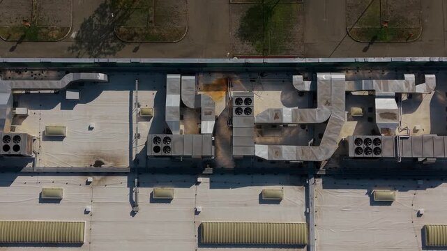 Rooftop Industrial HVAC Systems: An aerial view reveals complex HVAC ductwork and industrial machinery on the rooftop of a commercial building.