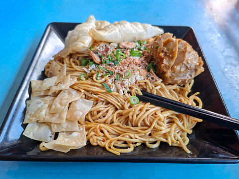 Savory Asian Noodles with Meatballs, Fried Dumplings, and Fresh Garnishes Ready to Eat