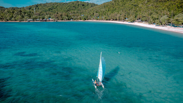 Group of sailer are enjoy sailing the dinghy boat at the corner of the tropical island together