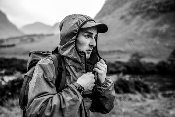 Hiker in rain jacket trekking through rugged mountain landscape © Rawpixel.com