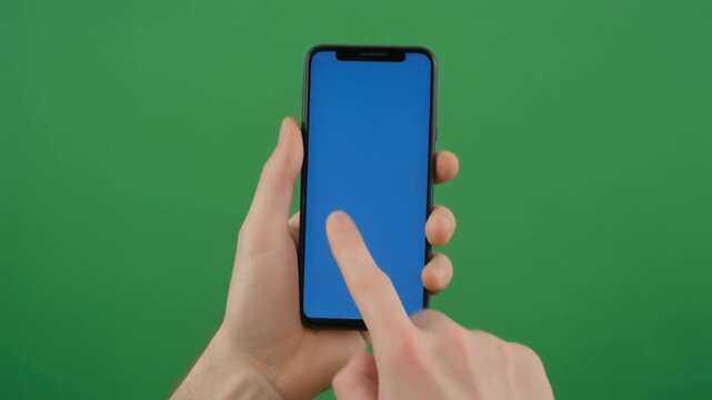 person swiping and tapping smartphone screen with blue display, green background