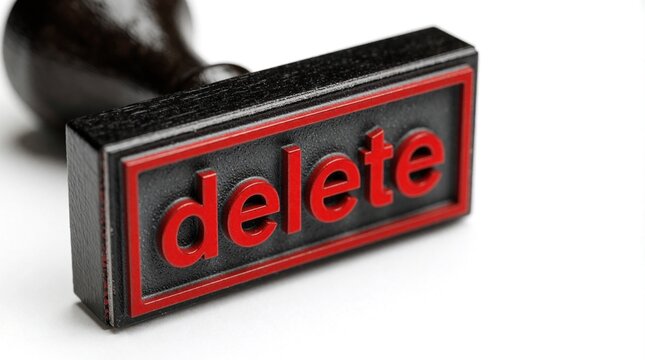 Close up of black rubber stamp with red word delete on white background. Office tool marks document for removal cancellation. Concept of erasing data, rejecting files, ending process in business