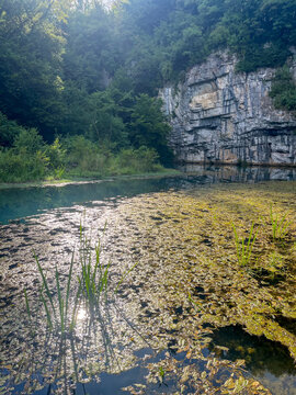 A slow-moving river with majestic rocks rising above it.