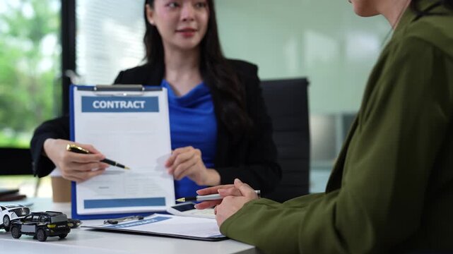 Automotive Business, Car Sale or Lease Concept: Car Dealership and sign contracts in car showrooms or car dealership offices.