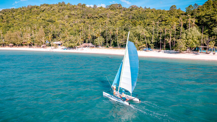 Group of sailer are enjoy sailing the dinghy boat at the corner of the tropical island together © ID_Anuphon