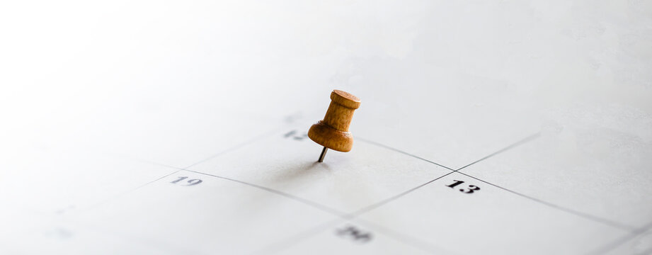 Desk calendar with pushpins for schedule management concept.