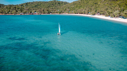 Group of sailer are enjoy sailing the dinghy boat at the corner of the tropical island together © ID_Anuphon