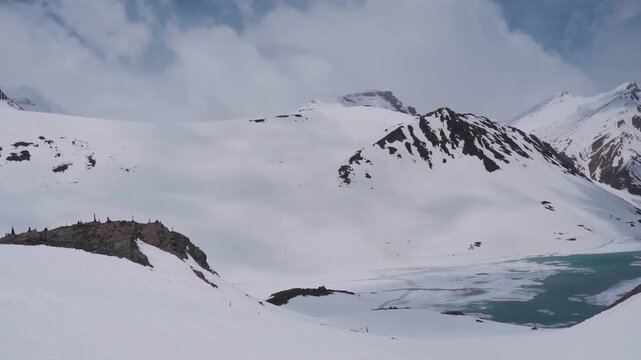 Wide angle shot of frozen Suraj Tal lake during the summer season as seen on the way towards Baralacha Pass Leh Manali highway in Lahaul and Spiti district, Himachal Pradesh, India. High Altitude lake