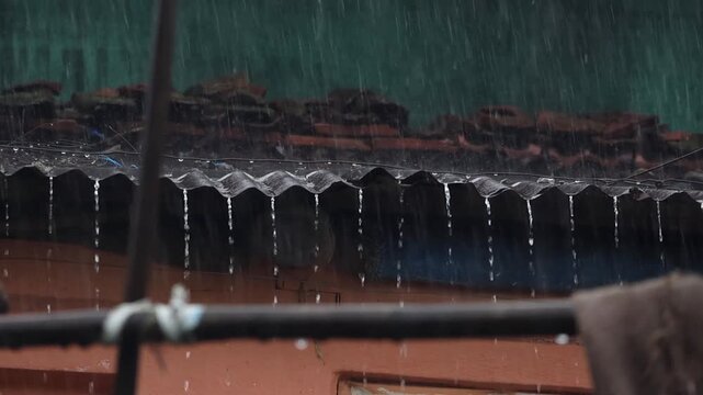 Water Streaming Down from Corrugated Shed Roof in Heavy Rain. Steady shot capturing constant rain streams and droplets cascading off the edge of a plastic corrugated roof overhang.