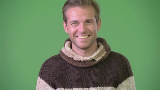 Man inviting gesture with a smile during a studio shoot with a green screen backdrop