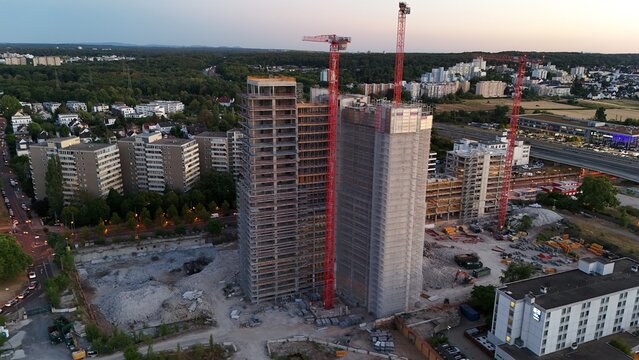 Aerial view of Keppel Data Center Reit construction site with two high-rise buildings, red cranes, and surrounding urban infrastructure during golden hour Offenbach am Main, Hessen, Germany.