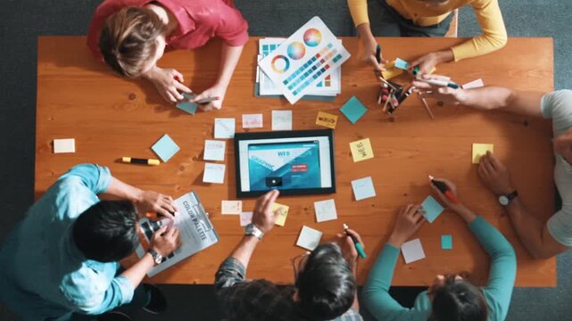 Time lapse of smart business people working together to design web design. Aerial view of designer brainstorming and discussing about website interface for computer or digital application. Symposium.