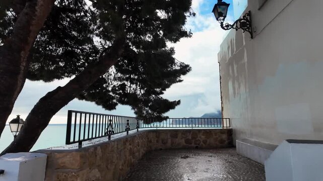 First-person walk to viewpoint under trees, Altea old town, Spain