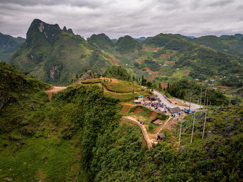 Aerial view of Ha Giang Loop with winding roads, lush green mountains, and rocky terrain in Dong Van, Tuyen Quang, Vietnam.
