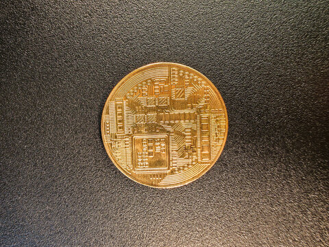 Golden physical bitcoin coin with circuit board pattern