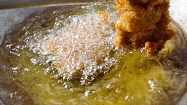close up of a pan fried chicken. method of deep frying in the oil.