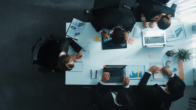Top down aerial view of business people brainstorm financial plan by using colorful sticky notes at meeting while businessman looking at financial statistic and analyze financial data. Directorate.