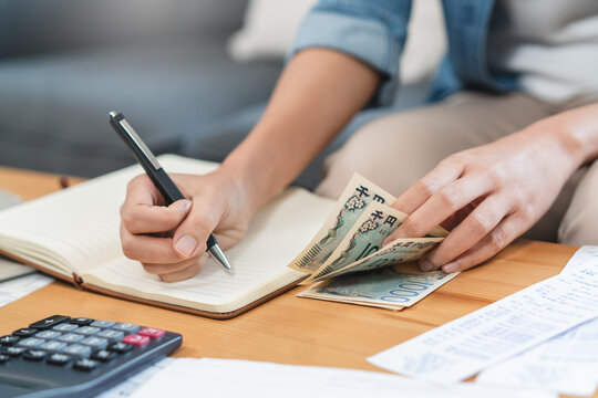 Economic inflation problem concept with close-up hands of woman counting cash money and calculating income for monthly expenses, financial crisis and home budget