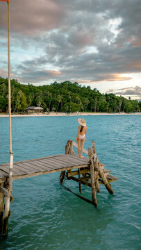 Woman tourist in happiness and relax moment on wooden pier, enjoy the summer trip in tropical island