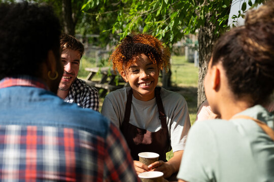 Happy young adults smiling and talking together at an outdoor gathering