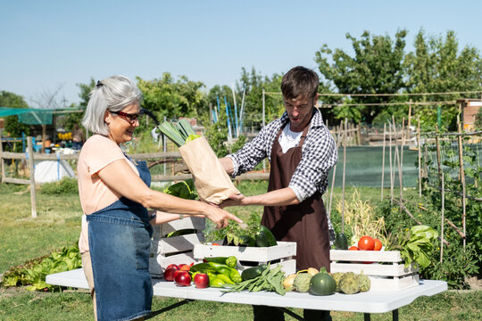 Farmers selling fresh produce and vegetables from their garden at a local market stall