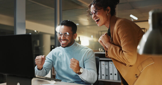 Computer, fist pump and success with business people in office at night for goals or target. Celebration, collaboration and milestone with employee team in workplace for achievement, bonus or victory