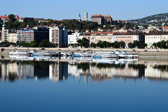 Budapest skyline with residential buildings along the Danube river on the Buda side. August, 2026. white hotel and tour boats moored along the shore line. bright residential apartment buildings 