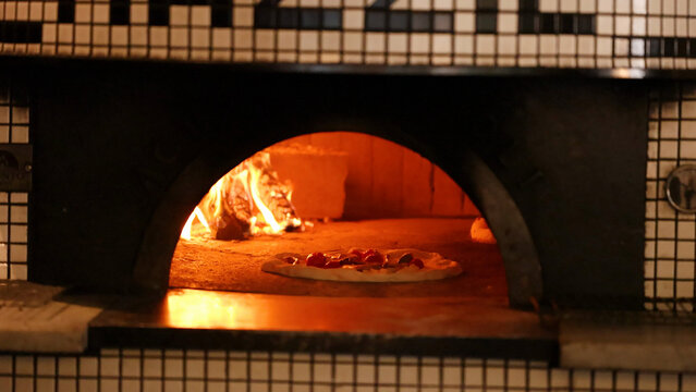 Fresh Pizza Baking Inside a Traditional Wood Fired Brick Oven