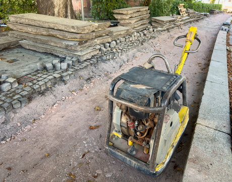 Plate Compactor at an Urban Path Construction Site &ndash; Roadworks, Ground Compaction and Infrastructure Development