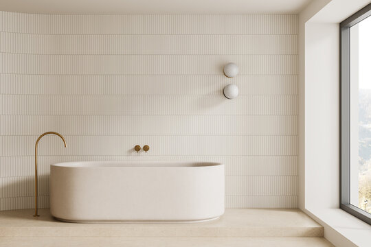 Contemporary beige bathroom interior with freestanding bathtub, linear wall tiles, brass fixtures, and panoramic window design. 3D Rendering