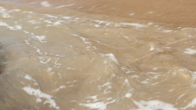 Freshly Cut Green Coconut Drink with a Sea Wave Splashing Over It at a Tropical Beach