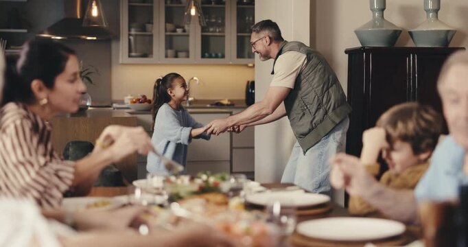 Father, child and dancing at family dinner in house with love, energy and happiness or bonding. Man, daughter or people together in dining room for food, fun and spin with learning, gathering or meal