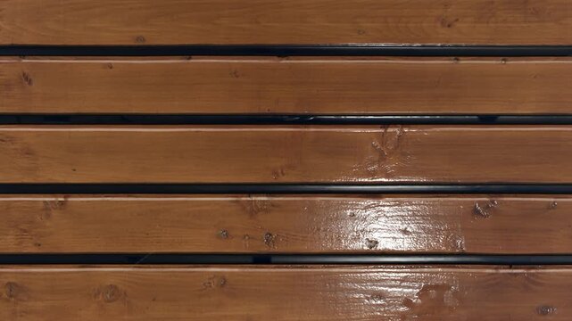Close-up slow pan of polished hardwood floor planks with natural grain and warm tones
