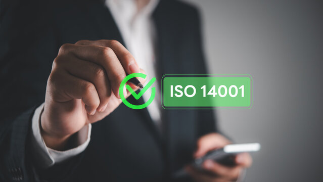 Businessman holding pen pointing ISO 14001 environmental management certification checkmark smart composite corporate sustainability compliance ecology business strategy green standard