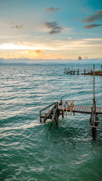Couple tourist in happiness and relax moment on wooden pier, enjoy the summer trip in tropical island