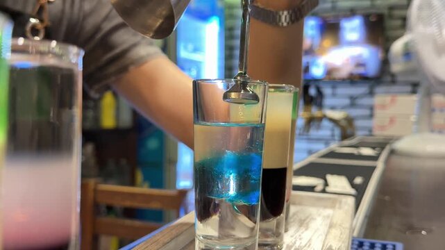 Blue Curacao Poured into Clear Vodka While Preparing a Bright Blue Cocktail Shot