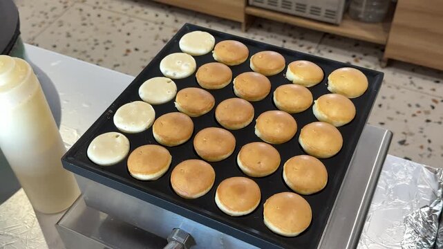 Mini Pancakes Cooking on a Special Griddle Until Golden Brown